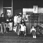 women in 1975 in front of a window with "Auckland Women's Centre" stencilled on it