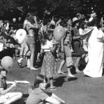 people and balloons in a park, black & white image