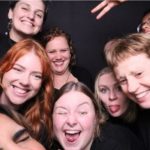 people smiling and posing in a photo booth