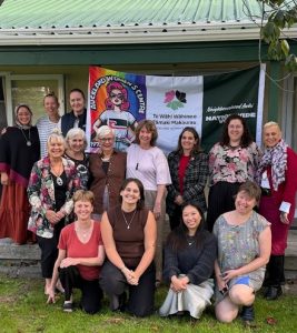women pose in front of AWC banners at the Centre